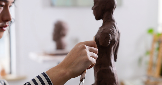 年轻男艺术家专注雕刻塑像特写视频