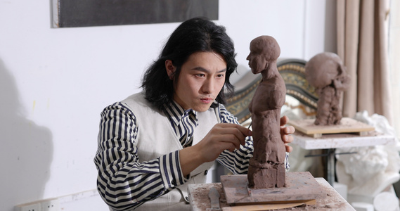 年轻男艺术家专注雕刻塑像作品视频