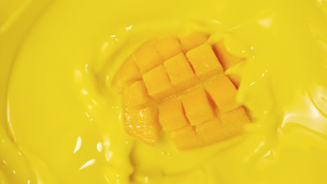 4K金黄芒果落入果汁水中17秒视频