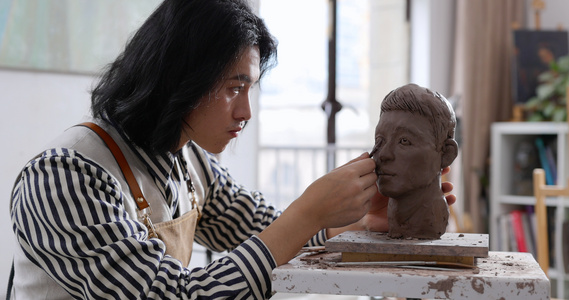年轻男艺术家专注雕刻塑像视频