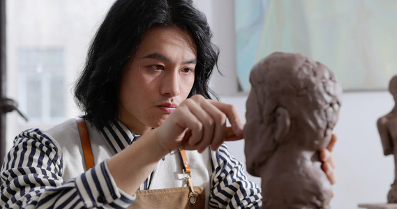 年轻男艺术家专注雕刻雕塑视频