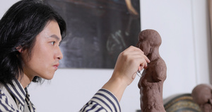 年轻男艺术家专注雕刻塑像17秒视频