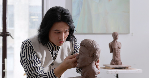 年轻男艺术家专注雕刻塑像视频
