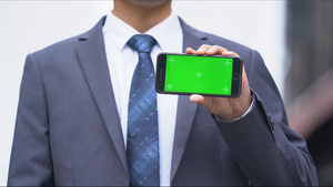 4k穿西装的办公男生展示绿幕手机21秒视频