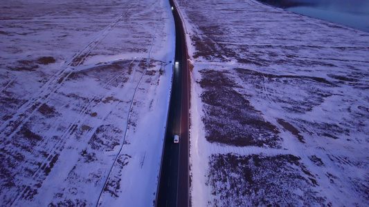 傍晚行驶在雪地公路的汽车视频