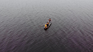 3名男子穿着橙色救生衣在湖边的橘色船上捕鱼13秒视频
