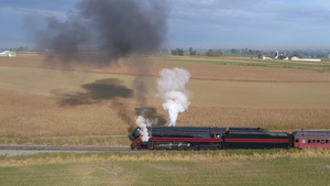 蒸汽机的恢复后蒸汽机空中侧面在拖着客车驶往农田时发8秒视频