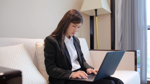 商务女性坐在沙发上使用笔记本电脑30秒视频