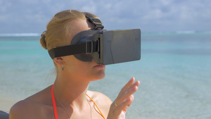 女人在沙滩上使用虚拟现实眼镜37秒视频