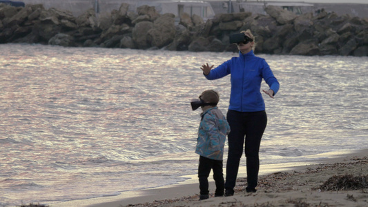 母亲和儿子在岸边与Vr眼镜玩得开心视频