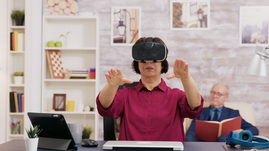 退休的老年妇女在使用虚拟现实护目镜时感到惊讶视频