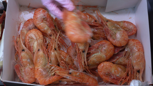 近手手显示鱼市柜台上的冷冻海鲜虾视频