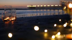 玻璃烛火海浪浪漫海滩约会夏日大海沙滩上的烛光25秒视频