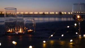 玻璃烛火海浪浪漫海滩约会夏日大海沙滩上的烛光10秒视频