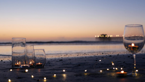 玻璃烛火海浪浪漫海滩约会夏日大海沙滩上的烛光15秒视频