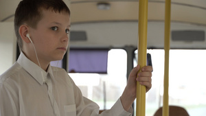 一名男孩乘公车穿过城市的近距离拍摄他收听音乐25秒视频