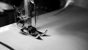 关闭白织物上的缝纫机针缓慢运动黑白色彩和黑色颜色10秒视频
