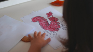 小女孩在纸页上涂着松鼠的画像上面印着红标记9秒视频