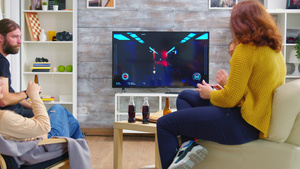 在电视上玩电子游戏的年轻女子的背影19秒视频