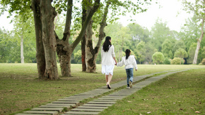 4K实拍妈妈和女儿走在公园的小路上33秒视频