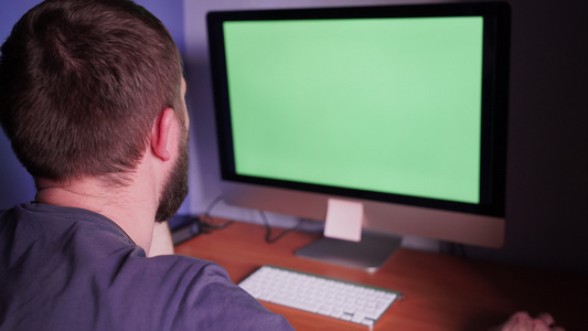一个人在电脑上用绿色屏幕的人视频