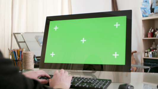 男性手在带有绿色屏幕的计算机上打字视频