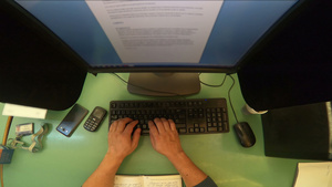 男人工作的方式是在绿色桌上使用台式计算机手在键盘上29秒视频