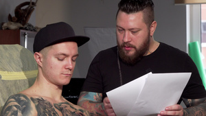 长胡子的纹身艺术家与男性客户讨论草图9秒视频
