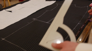 裁缝在工作用粉笔在黑色条纹织物上画线时装设计师或裁缝19秒视频