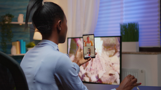 在网络摄像头上与使用智能手机的家庭进行讨论的黑人年轻视频