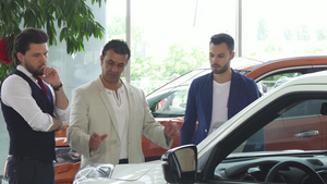 三名男性朋友在经销店检查汽车销售情况9秒视频