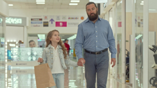 慈爱的父亲带着他可爱的小女儿在购物中心散步视频