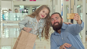 可爱的小女孩在商场和父亲自拍10秒视频
