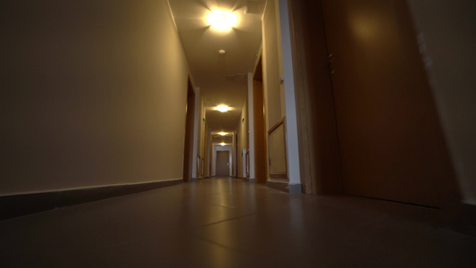 低角度电影拍摄镜头向酒店走廊走去的第一视角中弹视频
