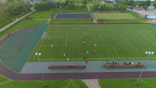 球员在城市公园踢足球空中观光Y我直飞到右边的绿色足球场视频