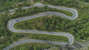 蓝色汽车在夏日在挪威山区蜿蜒的道路上行驶绿色森林空中27秒视频