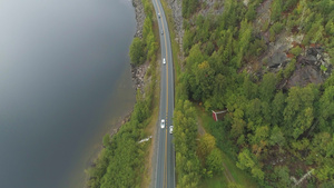 夏天阴天汽车在挪威湖附近的乡村公路上行驶空中显示视图11秒视频