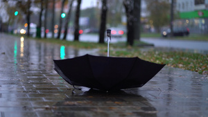 在雨季有人在路上投掷黑色雨伞7秒视频