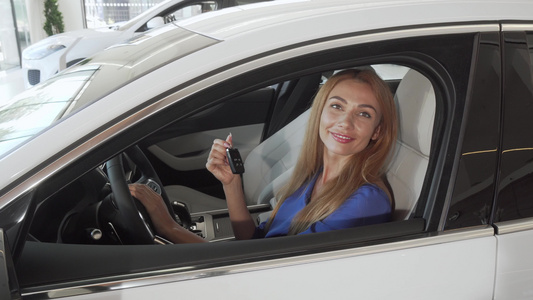 快乐的女司机笑着拿着她新车钥匙的汽车钥匙视频