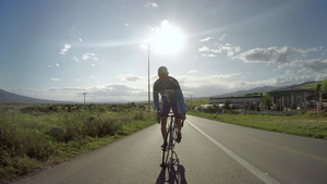 骑自行车者尽最大努力在路边运动中在山上赛跑背景是日落24秒视频