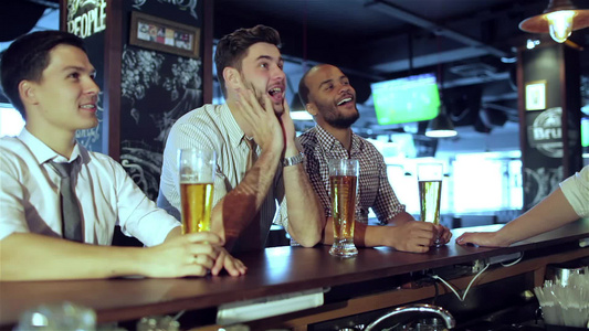 男性球迷在电视上看足球和喝啤酒视频