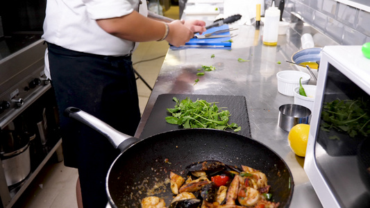 餐盘上装着海产食品的厨师和手持钳子的厨师视频
