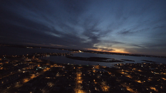 日落全景观光照亮了小村镇的海湾无人驾驶飞机在夜间飞行视频