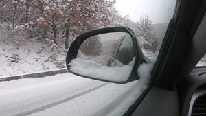 在冬季雪雪中驾驶车在雪覆盖的雪山路上行驶通过侧面镜子27秒视频
