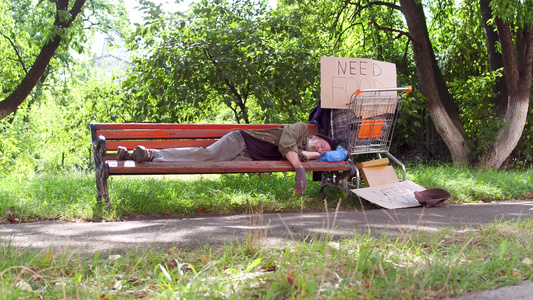 流浪老人在城市公园的长椅上视频