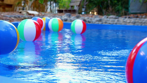 漂浮在游泳池中的彩色海滩球21秒视频