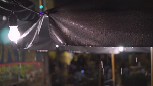 倾盆大雨中的户外老城街咖啡馆天篷灯笼和灯泡15秒视频