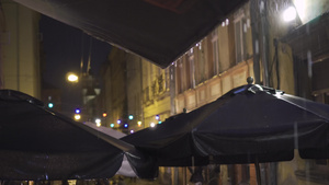 夜间大雨中的户外街边咖啡馆雨滴从树冠上掉下来灯笼挂20秒视频