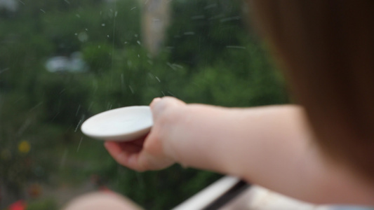 小手在模糊的背景下捕捉雨滴纯新鲜生态小女孩玩雨雨滴视频