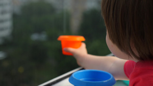 孩子接雨滴呆在家里的概念下雨天用盘子接水滴快乐的童年17秒视频
